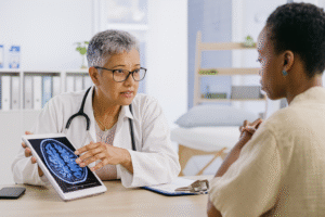 A female doctor showing a patient stroke warning signs in a brain scan during a neurological consultation