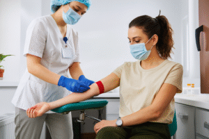 Nurse preparing to draw blood from a female patient for anemia testing