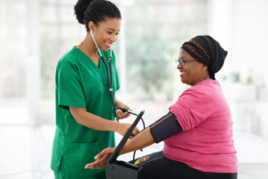Healthcare provider in green scrubs checking blood pressure during an annual wellness visit in Garland TX